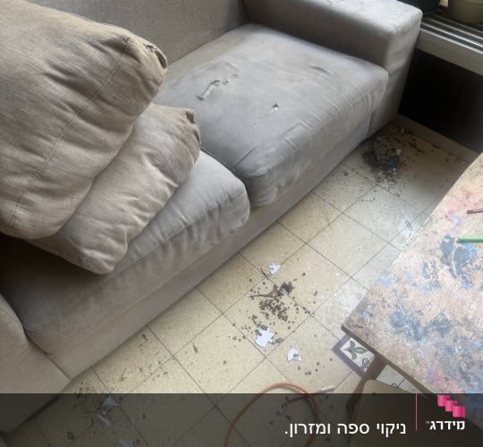 ספה מלוכלכת עם כריות על הרצפה
